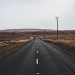 empty black road near utility post